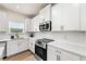 Well-lit kitchen featuring white cabinetry, quartz countertops, stainless steel appliances, and subway tile backsplash at 228 Whitneys Way, Dallas, GA 30157