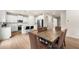 Modern kitchen and dining area featuring white cabinetry, stainless steel appliances, and a wooden dining table at 228 Whitneys Way, Dallas, GA 30157