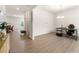 Open-concept living room with light wood floors, neutral walls, chandelier lighting, and view into kitchen and entryway at 228 Whitneys Way, Dallas, GA 30157