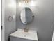 Modern bathroom vanity featuring updated fixtures, lighting, and a round mirror at 3510 Dunn Se St, Smyrna, GA 30080