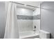Bathtub with shower combination featuring white tiling and a shower curtain at 3510 Dunn Se St, Smyrna, GA 30080