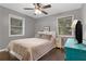 Cozy bedroom with a ceiling fan, two windows, and a stylish turquoise dresser at 3510 Dunn Se St, Smyrna, GA 30080
