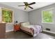 This bedroom has two windows with wood trim and a ceiling fan at 3510 Dunn Se St, Smyrna, GA 30080