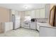 Efficient kitchen with white appliances, cabinetry, and tiled flooring at 3510 Dunn Se St, Smyrna, GA 30080