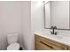 Modern powder room featuring a wood vanity, matte black fixtures and rectangular framed mirror at 3524 Preserve Run Trl, Loganville, GA 30052