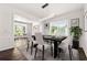 Elegant dining room featuring hardwood floors, a modern light fixture, and white chairs at 3524 Preserve Run Trl, Loganville, GA 30052
