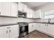 Well-equipped kitchen featuring white cabinets, stainless steel appliances, granite countertops, and modern fixtures at 3524 Preserve Run Trl, Loganville, GA 30052