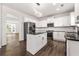 Modern kitchen featuring white cabinets, black appliances, granite countertops, and an island with an open layout at 3524 Preserve Run Trl, Loganville, GA 30052