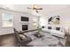 Inviting living room featuring a fireplace, plush seating, a ceiling fan, and large windows for abundant natural light at 3524 Preserve Run Trl, Loganville, GA 30052