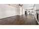 Open-concept living room featuring hardwood floors, a fireplace, and an airy atmosphere with an adjacent modern kitchen at 3524 Preserve Run Trl, Loganville, GA 30052