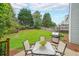 Backyard featuring a patio with table and chairs, a grill, and a green lawn at 626 Dahoma Trail Trl, Woodstock, GA 30188