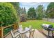 View of backyard featuring a well manicured lawn, patio table, and chairs with BBQ grill at 626 Dahoma Trail Trl, Woodstock, GA 30188