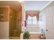 Bright bathroom features a tiled glass-enclosed shower, a garden tub and decorative fixtures at 626 Dahoma Trail Trl, Woodstock, GA 30188