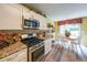 Eat-in kitchen features stainless appliances, granite counters, and wood floors at 626 Dahoma Trail Trl, Woodstock, GA 30188