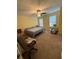 Bedroom features light-yellow walls, carpet, ceiling fan, and two windows that let in natural light at 6550 Wellington Chase Ct, Lithonia, GA 30058