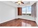 Bright bedroom featuring hardwood floors, ceiling fan, and large window with charming brown shutters at 2881 Peachtree Ne Rd # 1202, Atlanta, GA 30305