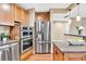Kitchen with stainless steel appliances, granite counters, wooden cabinets, and adjacent dining area at 2881 Peachtree Ne Rd # 1202, Atlanta, GA 30305