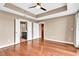 Large main bedroom featuring wood flooring, tray ceiling, and double doors leading to a bathroom and closet at 2881 Peachtree Ne Rd # 1202, Atlanta, GA 30305
