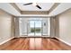 Spacious main bedroom with wood floors and large glass doors leading to a balcony with a picturesque view at 2881 Peachtree Ne Rd # 1202, Atlanta, GA 30305