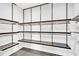 Walk-in closet featuring modern metal shelving with wood trim and gray tile flooring at 2881 Peachtree Ne Rd # 1202, Atlanta, GA 30305