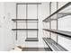 Modern walk-in closet with light gray tile flooring and adjustable metal shelving and wood trim at 2881 Peachtree Ne Rd # 1202, Atlanta, GA 30305