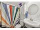 Bright bathroom featuring a pedestal sink, colorful shower curtain, and storage cabinet for a cheerful space at 405 Forest Valley Road, Sandy Springs, GA 30342