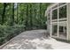A multi-story house featuring a concrete patio surrounded by a lush green forest at 405 Forest Valley Road, Sandy Springs, GA 30342