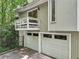Home with a two-car garage and an outdoor balcony surrounded by lush trees at 405 Forest Valley Road, Sandy Springs, GA 30342