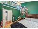 Cozy bedroom featuring unique green walls, a large bed, and access to a bathroom at 405 Forest Valley Road, Sandy Springs, GA 30342