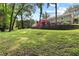 Large, gently sloping backyard with a retaining wall and stairs leading to a red-stained deck on the house at 621 Windgrove Se Rd, Marietta, GA 30067