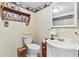 Cozy powder room with a pedestal sink, decorative wallpaper border, and charming wooden accents at 621 Windgrove Se Rd, Marietta, GA 30067