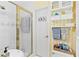 Bright bathroom featuring a glass-enclosed shower, white cabinets, and yellow striped wallpaper at 621 Windgrove Se Rd, Marietta, GA 30067