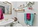 Cozy bathroom featuring floral accents, white fixtures, mirror, and patterned wallpaper for a vintage charm at 621 Windgrove Se Rd, Marietta, GA 30067