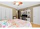 Bright bedroom with floral bedding, desk and white storage, featuring hardwood floors and ceiling fan at 621 Windgrove Se Rd, Marietta, GA 30067