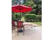 Cozy patio with outdoor seating and red umbrella perfect for summer entertaining at 938 Lost Valley Se Dr, Conyers, GA 30094