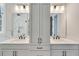 Well-lit bathroom featuring double vanities, modern fixtures, framed mirrors, and neutral accents at 1294 Six Sisters St, Dacula, GA 30019