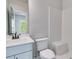 Bathroom with white fixtures, including a built-in shower seat and tiled walls at 1294 Six Sisters St, Dacula, GA 30019