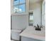 Bright bathroom featuring a white vanity, framed window and mirror with neutral colored accents at 1294 Six Sisters St, Dacula, GA 30019