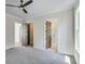 Bright bedroom featuring gray walls, neutral carpet, ceiling fan, and ensuite bathroom and closet at 1294 Six Sisters St, Dacula, GA 30019