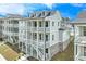 This exterior elevation shows units featuring three stories, porches on two levels, neutral paint and stone veneer at 1294 Six Sisters St, Dacula, GA 30019