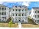 Three-story gray home with balconies, white pillars, and manicured lawn at 1294 Six Sisters St, Dacula, GA 30019