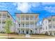 Three-story townhouse with a white exterior, multiple balconies, and manicured landscaping at 1294 Six Sisters St, Dacula, GA 30019