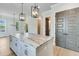Kitchen island with stainless steel appliances, granite countertops and stylish lighting at 1294 Six Sisters St, Dacula, GA 30019