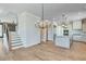 Open-concept living space with hardwood floors, modern lighting, and staircase at 1294 Six Sisters St, Dacula, GA 30019