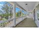Long covered porch lined with white columns and railings with wooded views at 1294 Six Sisters St, Dacula, GA 30019