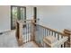 Staircase featuring light wood banister and dark metal spindles, leading to the upper level at 1294 Six Sisters St, Dacula, GA 30019