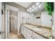 This bathroom is updated with a granite countertop, double sink vanity, and a shower/tub combo at 1975 Fairway Close Ter, Lawrenceville, GA 30043