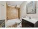 Bathroom with a tub/shower, white toilet, dark wood cabinet, and a framed mirror with natural light at 1975 Fairway Close Ter, Lawrenceville, GA 30043