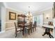 Bright dining room with a chandelier, wooden table and chairs, and access to the outdoor area at 1975 Fairway Close Ter, Lawrenceville, GA 30043