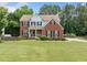 Beautiful two-story brick home with a well-manicured lawn and mature trees at 1975 Fairway Close Ter, Lawrenceville, GA 30043